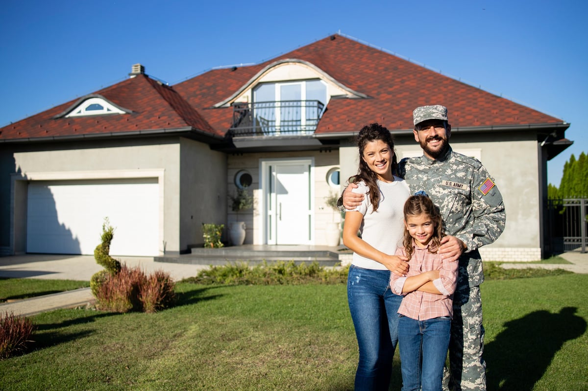 Happy American military family in front of their new home