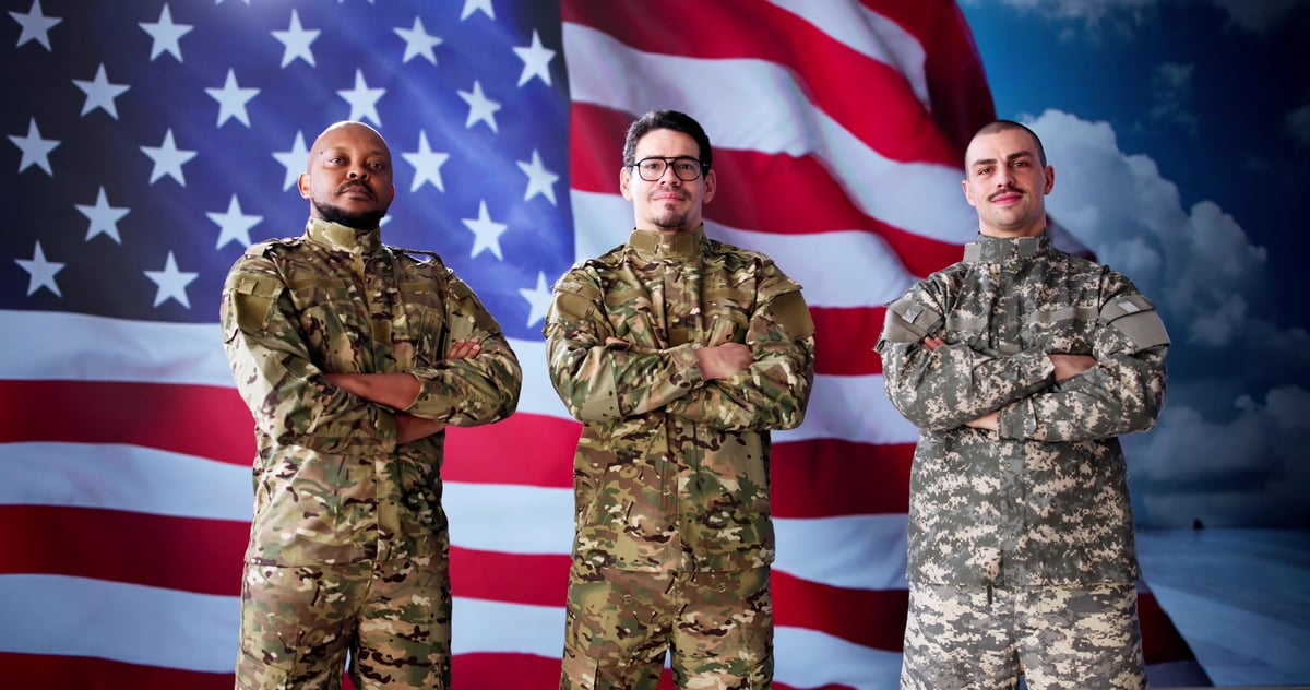 Veterans from a range of backgrounds saluting together in front of the American flag